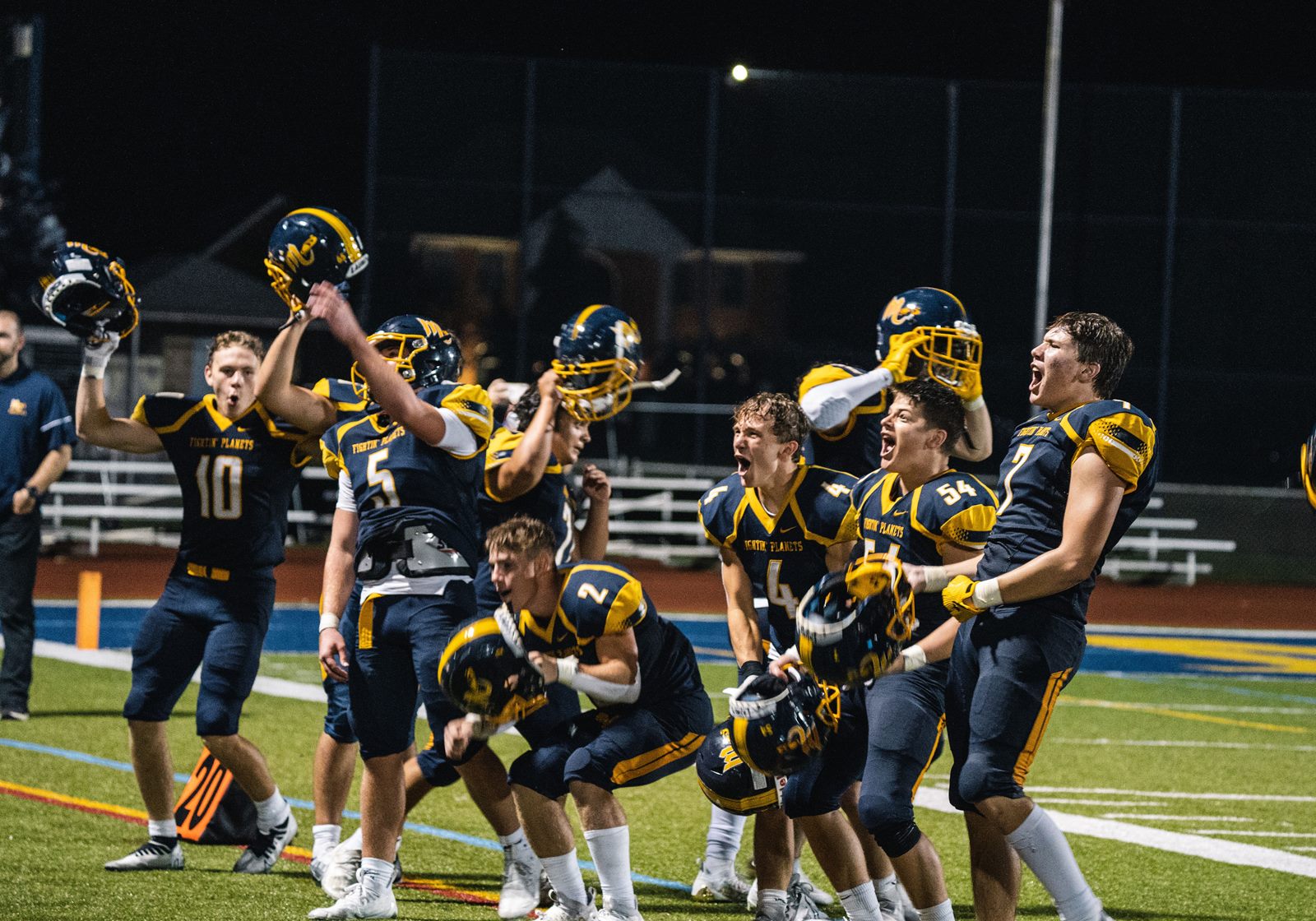 Mars Planets players celebrating on the field at a night game