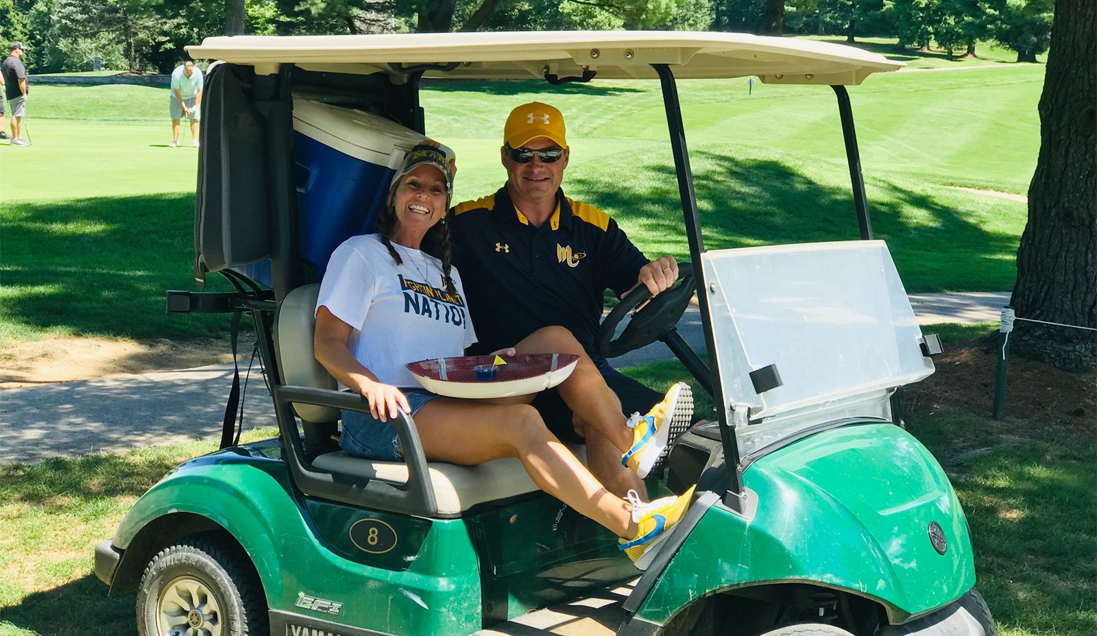 Golfers in a cart at the Mars Quarterback Club golf outing