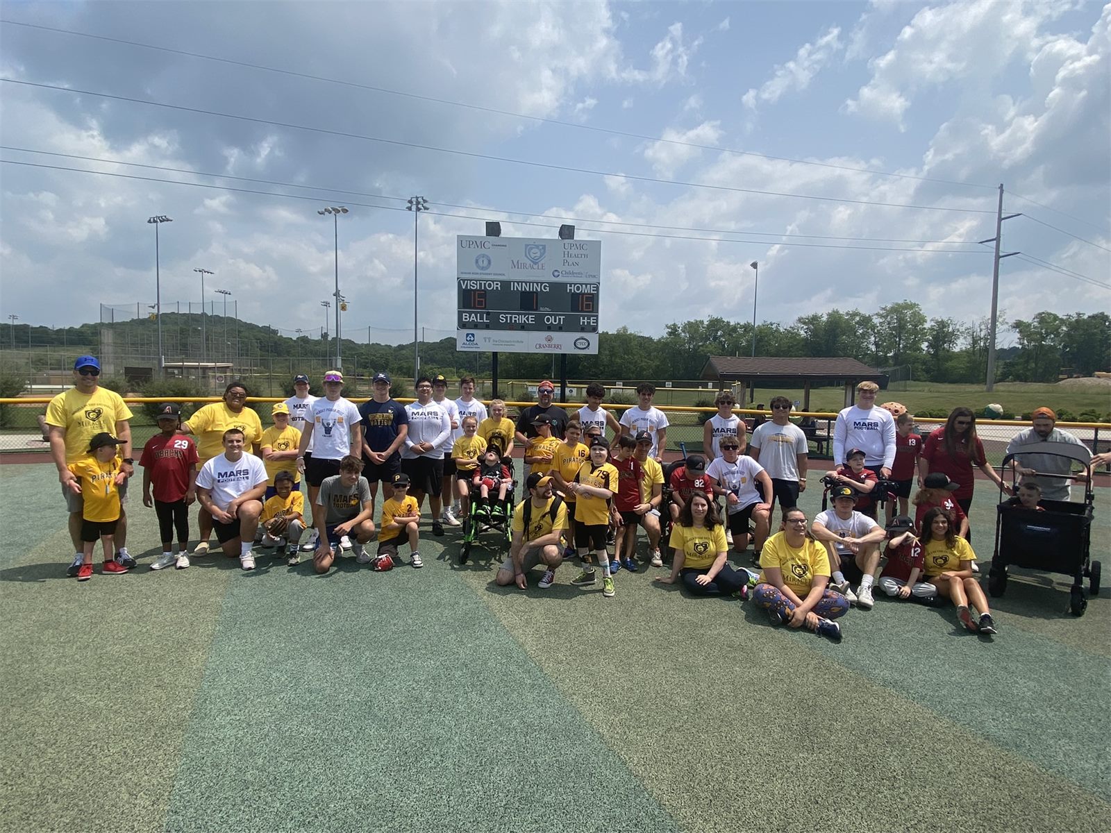 Mars football players with Miracle League athletes on the field