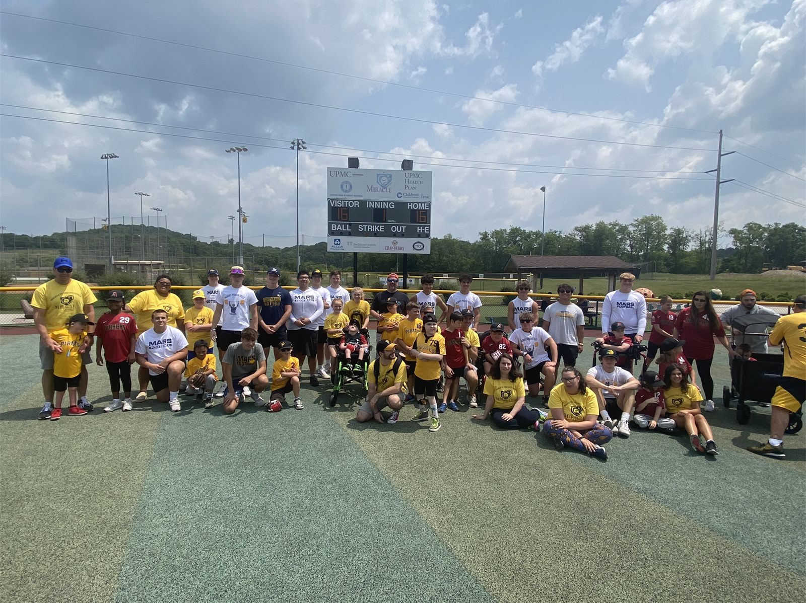 Mars football players with Miracle League athletes on the field