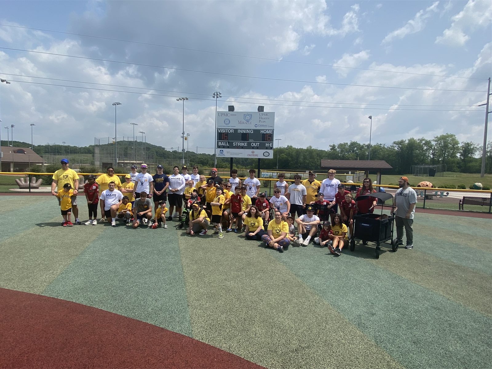 Mars football players with Miracle League athletes on the field