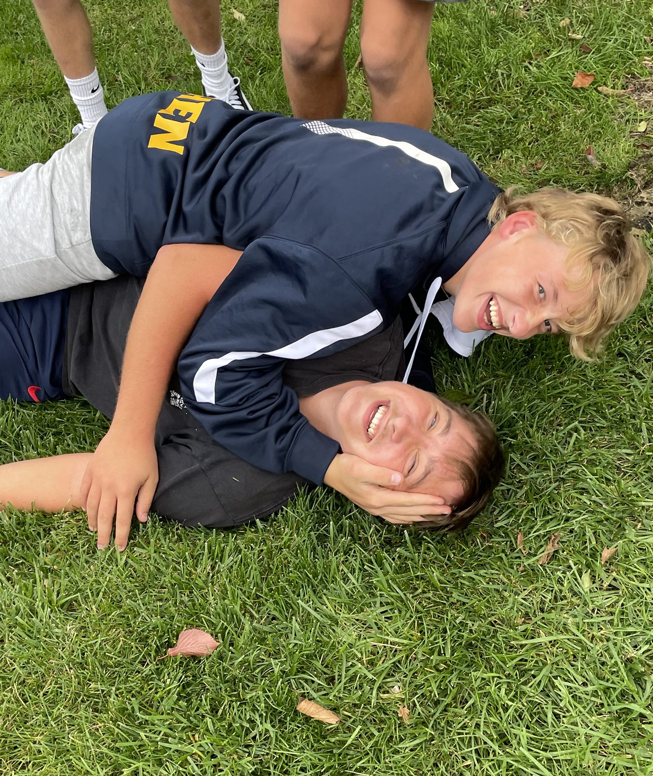 Players wrestling on the grass at a team spaghetti dinner