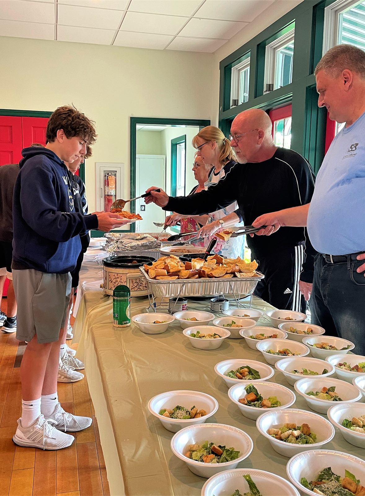 Players serving food at a team spaghetti dinner